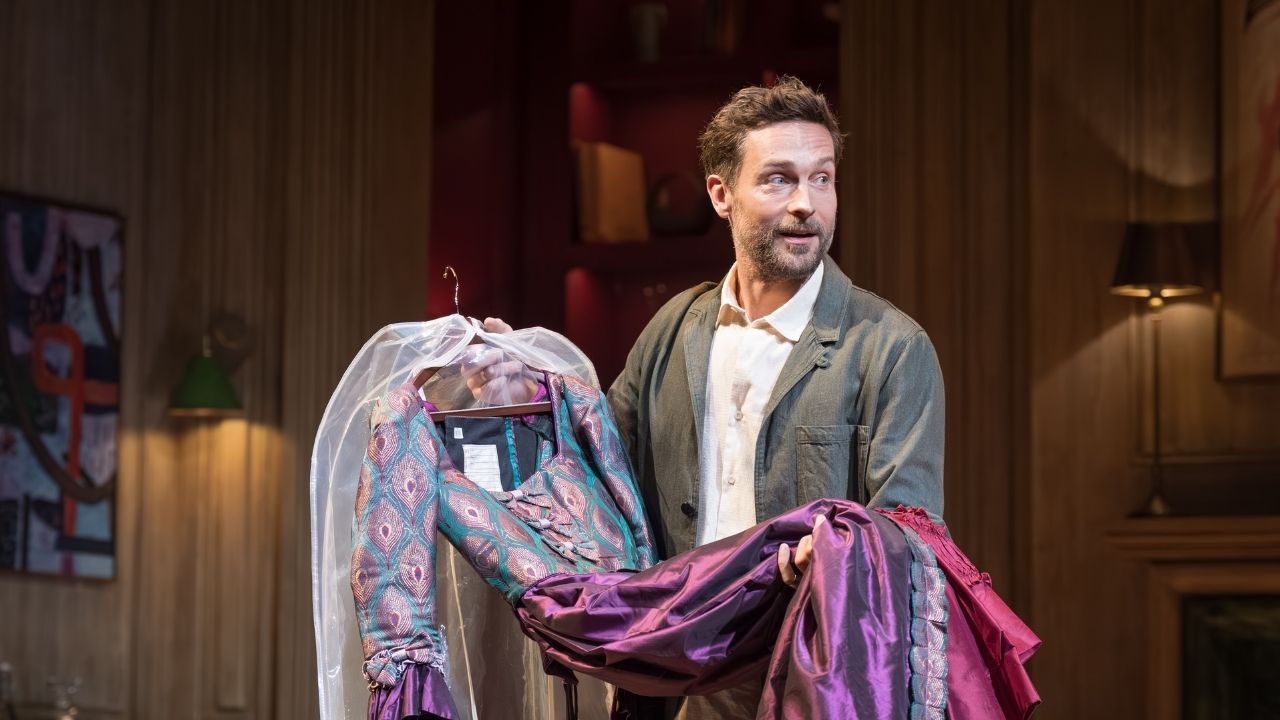 a man with a breard holding up a dress